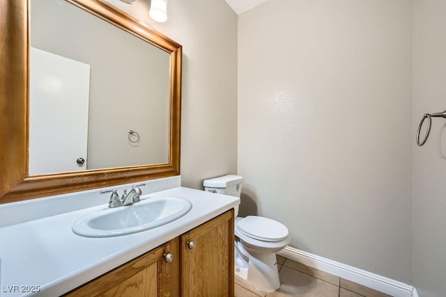 bathroom with tile patterned flooring, vanity, baseboards, and toilet