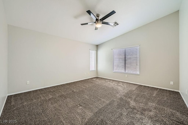 carpeted empty room with visible vents, baseboards, vaulted ceiling, and a ceiling fan