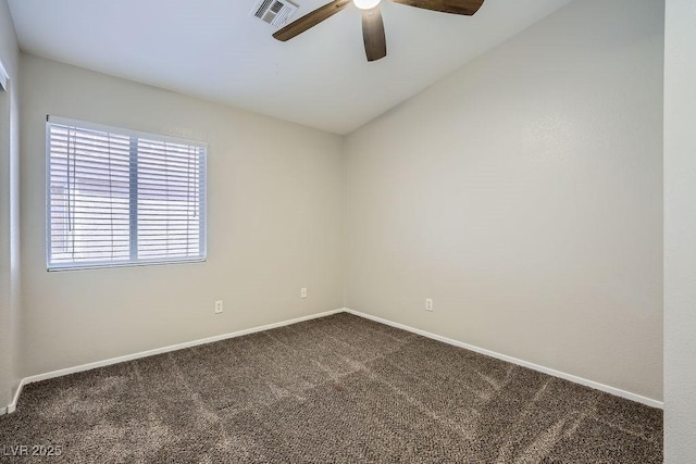 spare room featuring visible vents, baseboards, dark carpet, and ceiling fan