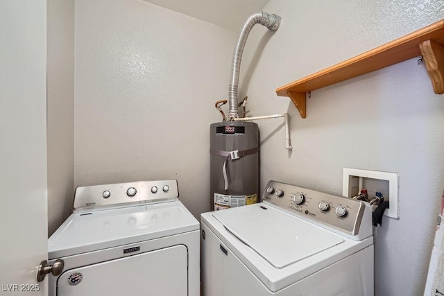 laundry room with water heater, washer and clothes dryer, and laundry area