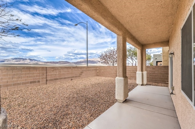 view of patio / terrace with a fenced backyard and a mountain view