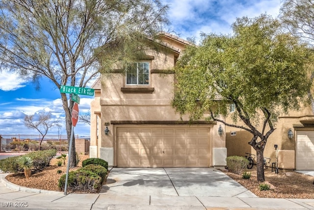 view of front facade with driveway, stucco siding, an attached garage, and a tiled roof