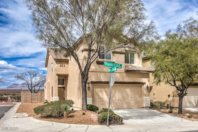 view of front of property with fence, stucco siding, an attached garage, and concrete driveway
