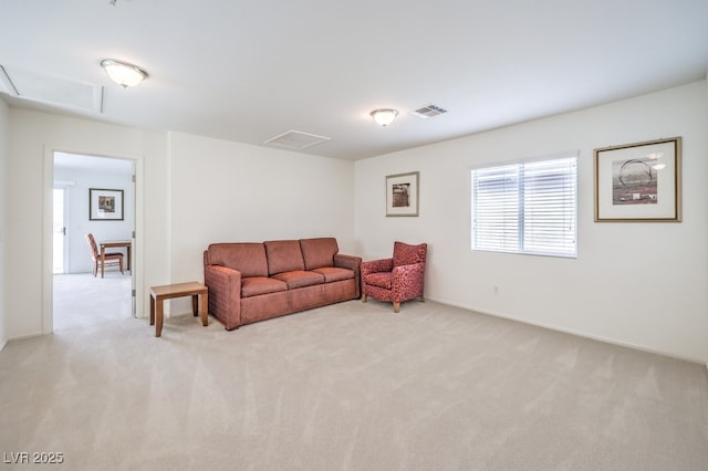 living area featuring light carpet and attic access