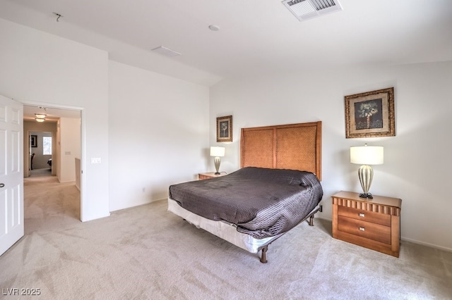 carpeted bedroom featuring vaulted ceiling and visible vents
