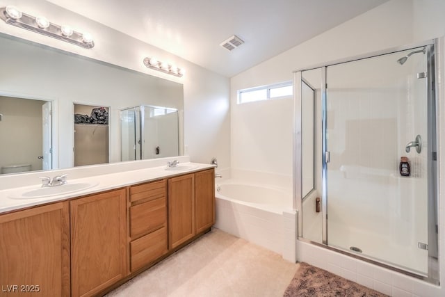 bathroom with a stall shower, visible vents, lofted ceiling, and a sink