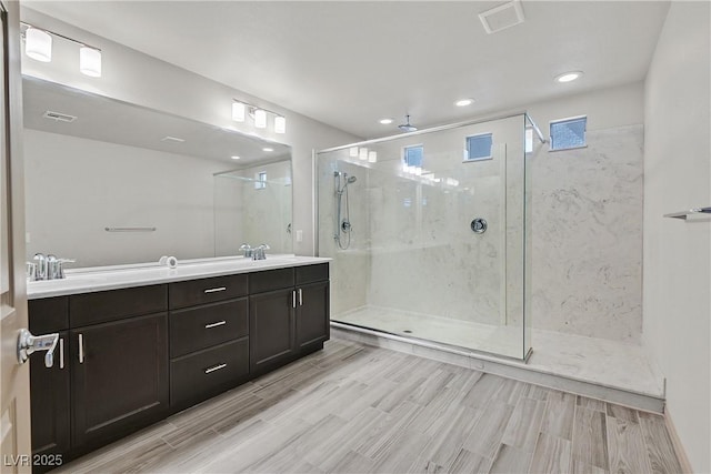 9830 Wild Coyote Ct, Las Vegas, NV 89141 - bathroom with a shower stall, double vanity, wood finished floors, and recessed lighting