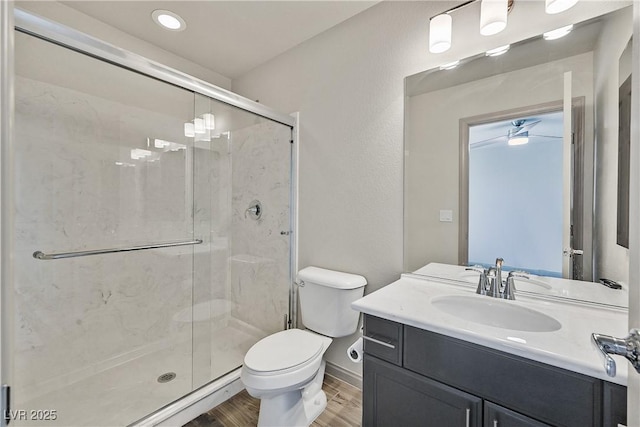 9830 Wild Coyote Ct, Las Vegas, NV 89141 - bathroom featuring toilet, wood finished floors, a stall shower, vanity, and baseboards