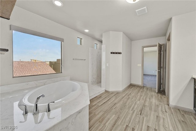 9830 Wild Coyote Ct, Las Vegas, NV 89141 - full bathroom featuring a garden tub, a marble finish shower, recessed lighting, wood finished floors, and baseboards