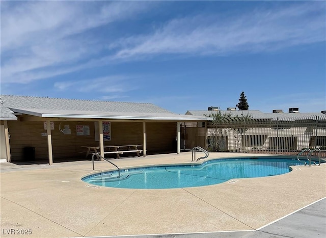 pool with a patio and fence