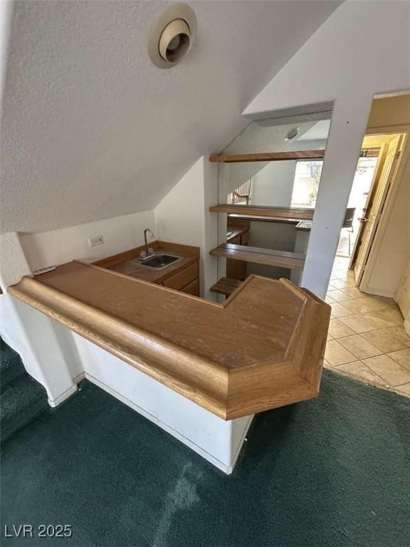 interior space featuring carpet flooring, a sink, and a textured ceiling