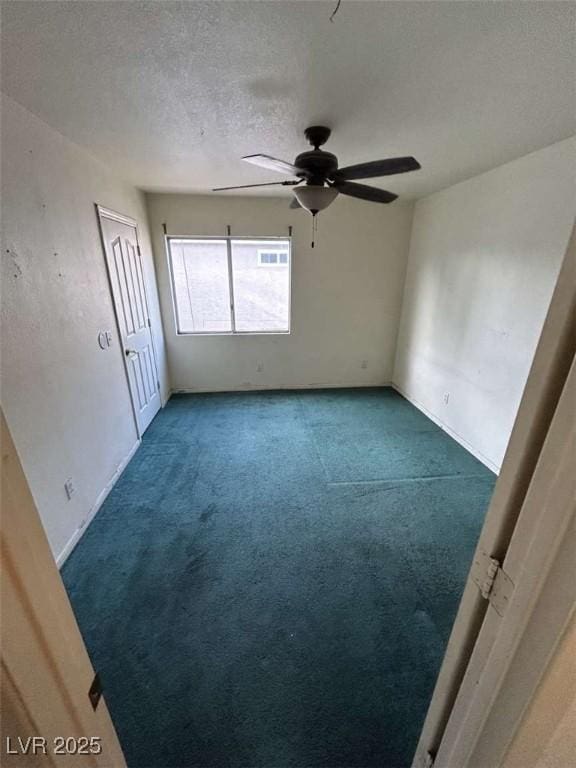 unfurnished room with carpet flooring, a textured ceiling, and a ceiling fan