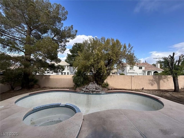 view of swimming pool featuring a fenced backyard, a fenced in pool, and an in ground hot tub