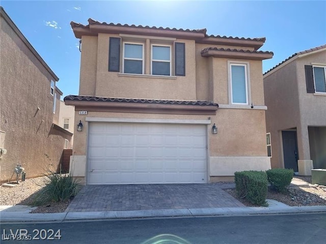 view of front of house featuring a tile roof, driveway, stucco siding, and an attached garage