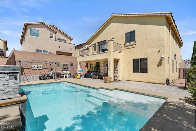 10437 Walworth Ave, Las Vegas, NV 89166 - back of property featuring a balcony, a fenced in pool, fence, a patio area, and stucco siding