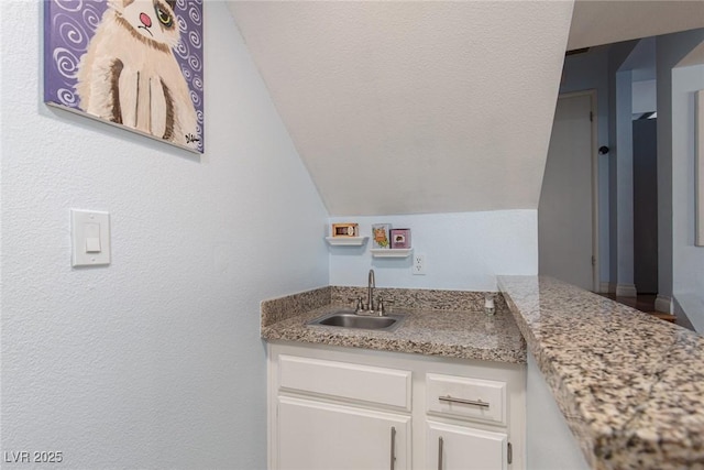 bathroom with vaulted ceiling and vanity