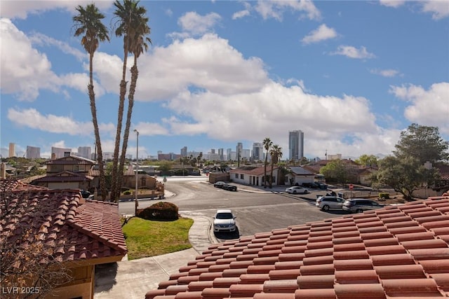 view of asphalt road with a view of skyline, sidewalks, and curbs