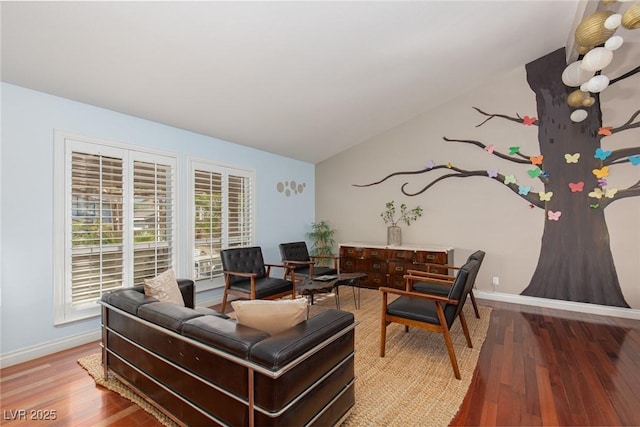 living area with wood finished floors, lofted ceiling, and baseboards