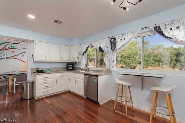 kitchen with dishwasher, dark wood finished floors, light stone countertops, white cabinets, and baseboards