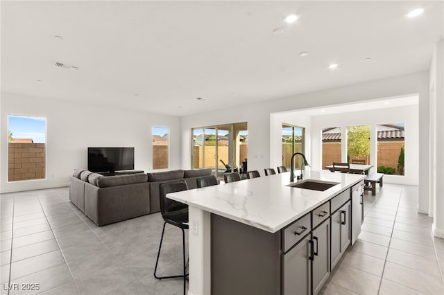 31 Autumn Palm Ave, Henderson, NV 89011 - kitchen with a sink, light tile patterned floors, a kitchen island with sink, recessed lighting, and a kitchen bar
