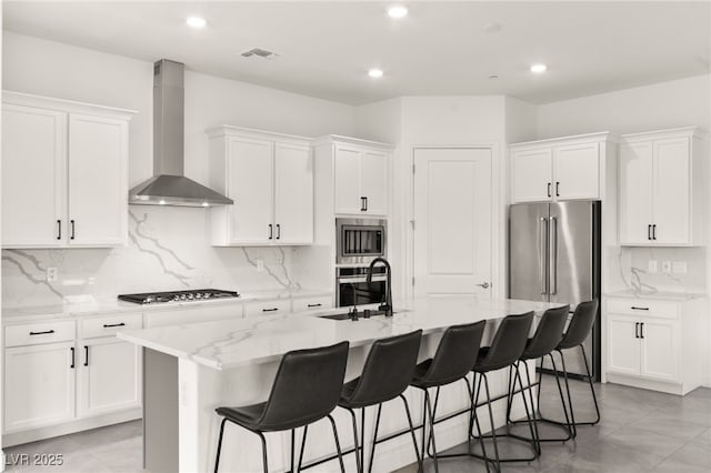 31 Autumn Palm Ave, Henderson, NV 89011 - kitchen with wall chimney exhaust hood, appliances with stainless steel finishes, a sink, a kitchen island with sink, and white cabinets