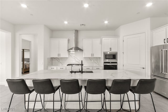31 Autumn Palm Ave, Henderson, NV 89011 - kitchen with appliances with stainless steel finishes, wall chimney exhaust hood, a sink, decorative backsplash, and white cabinetry