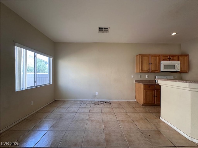 6080 Golden Corral Trl Unit 103, Henderson, NV 89011 - kitchen featuring white microwave, baseboards, light tile patterned floors, light countertops, and recessed lighting