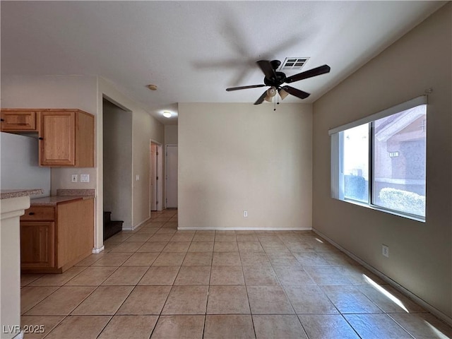 6080 Golden Corral Trl Unit 103, Henderson, NV 89011 - unfurnished living room featuring ceiling fan, light tile patterned floors, stairs, and baseboards