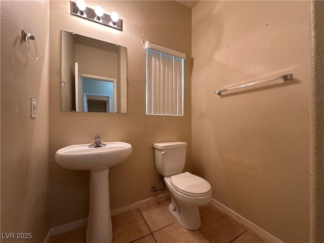 6080 Golden Corral Trl Unit 103, Henderson, NV 89011 - half bathroom featuring tile patterned flooring, toilet, baseboards, and a sink