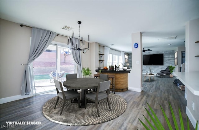 dining space featuring wood finished floors, baseboards, and visible vents