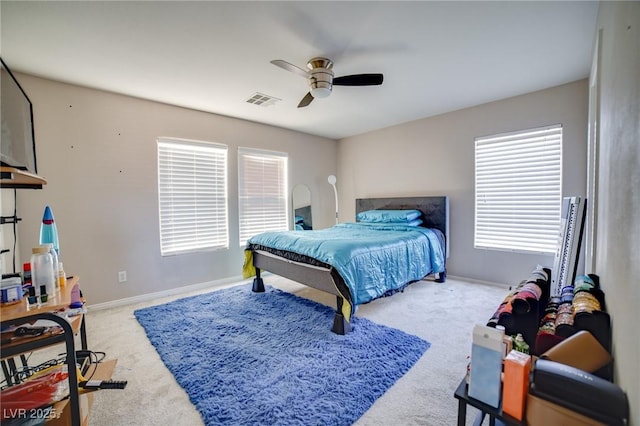 bedroom with baseboards, carpet flooring, visible vents, and a ceiling fan