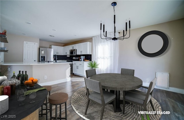 dining area with baseboards, dark wood-type flooring, and an inviting chandelier