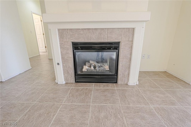 room details featuring baseboards and a tiled fireplace