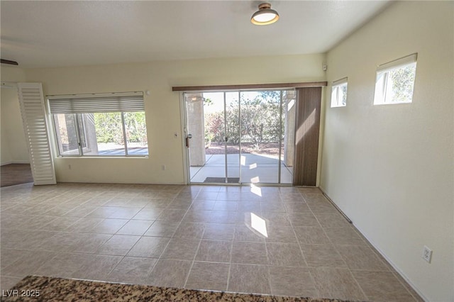 spare room with tile patterned flooring and a wealth of natural light