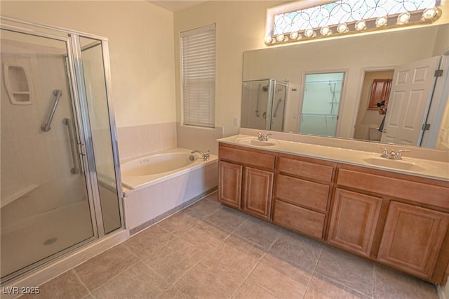 bathroom featuring double vanity, a sink, a stall shower, and a garden tub