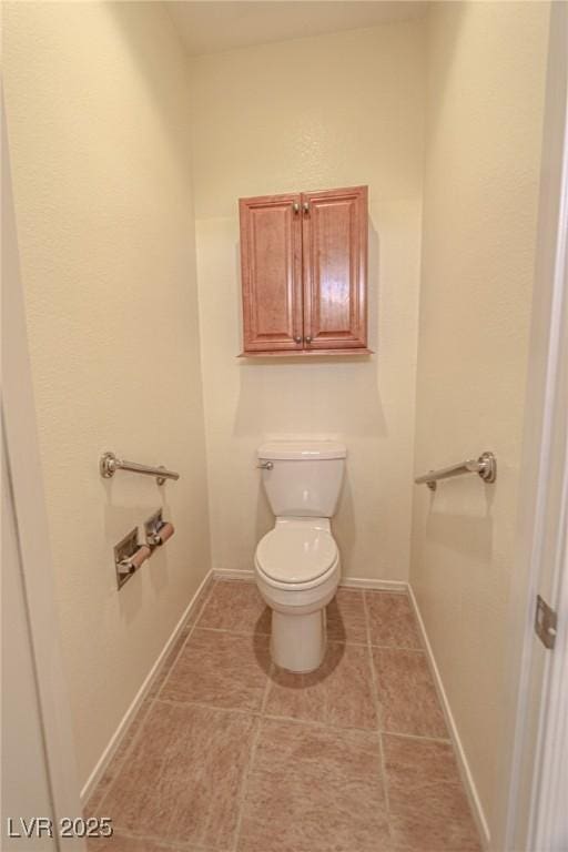 bathroom with toilet, tile patterned floors, and baseboards