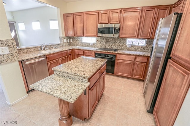 kitchen featuring a sink, a kitchen island, brown cabinetry, black appliances, and decorative backsplash