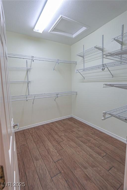 spacious closet featuring attic access and wood finished floors