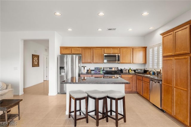 5224 E San Palo Dr, Pahrump, NV 89061 - kitchen featuring a center island, a breakfast bar, visible vents, appliances with stainless steel finishes, and brown cabinets