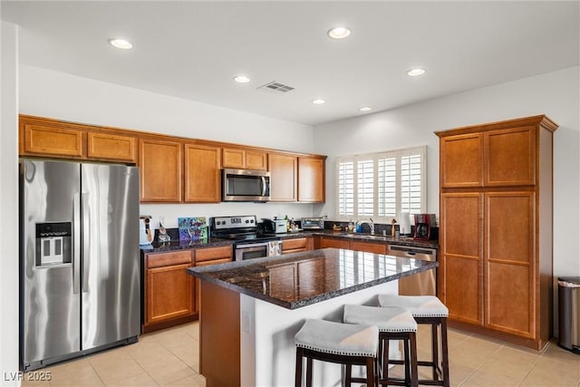 5224 E San Palo Dr, Pahrump, NV 89061 - kitchen featuring a kitchen island, stainless steel appliances, brown cabinetry, and visible vents