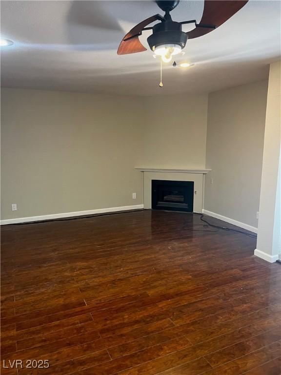 2541 Love St, Las Vegas, NV 89121 - unfurnished living room with dark wood-type flooring, a ceiling fan, baseboards, and a fireplace