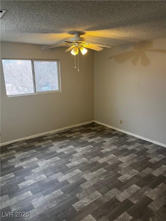 2541 Love St, Las Vegas, NV 89121 - unfurnished room featuring dark wood-style flooring, a ceiling fan, baseboards, and a textured ceiling
