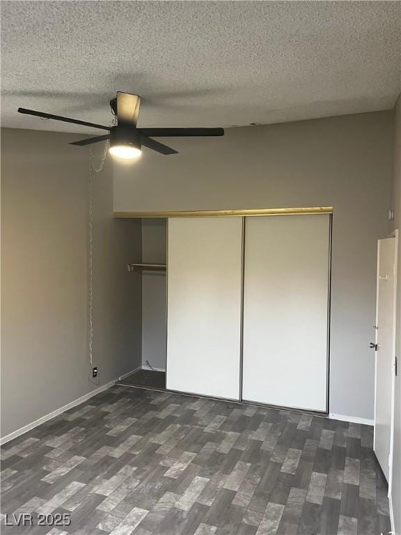 2541 Love St, Las Vegas, NV 89121 - unfurnished bedroom with dark wood-style floors, a textured ceiling, a closet, a ceiling fan, and baseboards