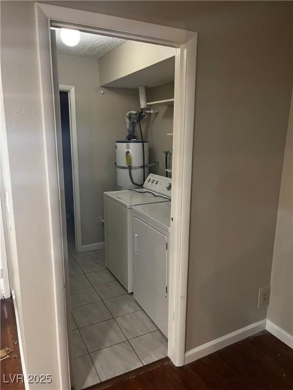 2541 Love St, Las Vegas, NV 89121 - laundry room featuring secured water heater, independent washer and dryer, baseboards, and light tile patterned floors
