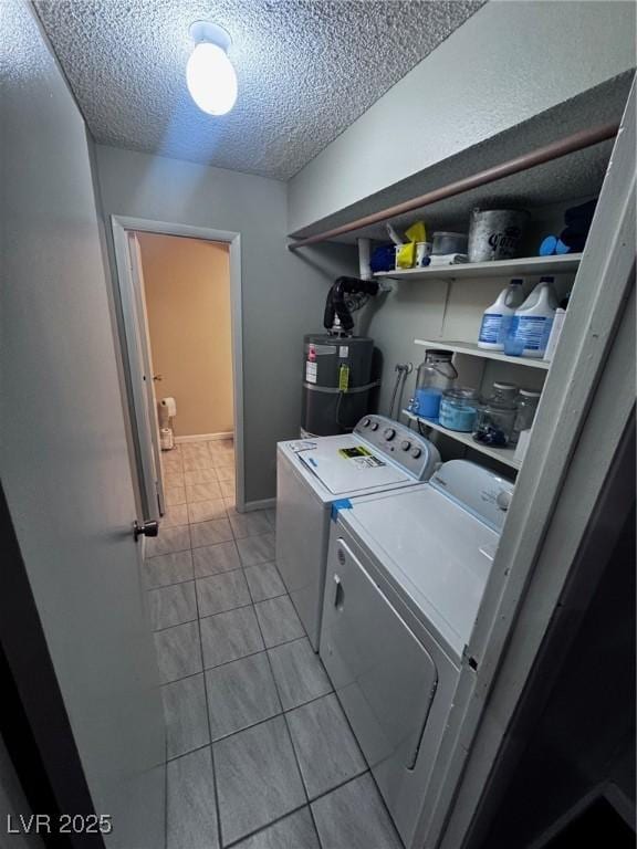2541 Love St, Las Vegas, NV 89121 - laundry room featuring strapped water heater, washing machine and dryer, a textured ceiling, and light tile patterned floors