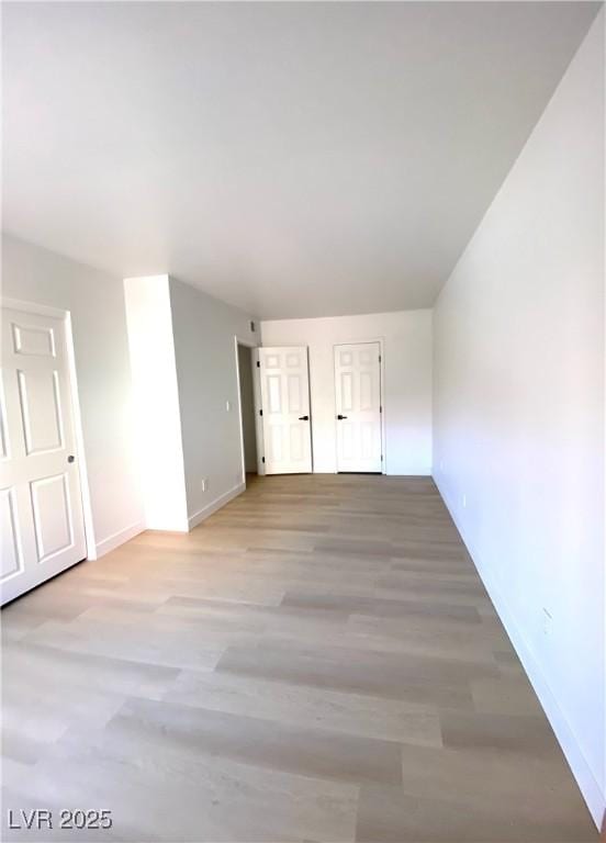 empty room featuring wood finished floors and baseboards