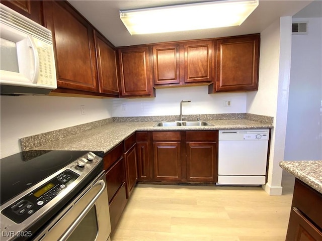4421 Alexis Dr Unit 429, Las Vegas, NV 89103 - kitchen featuring white appliances, a sink, light wood-style flooring, and light countertops