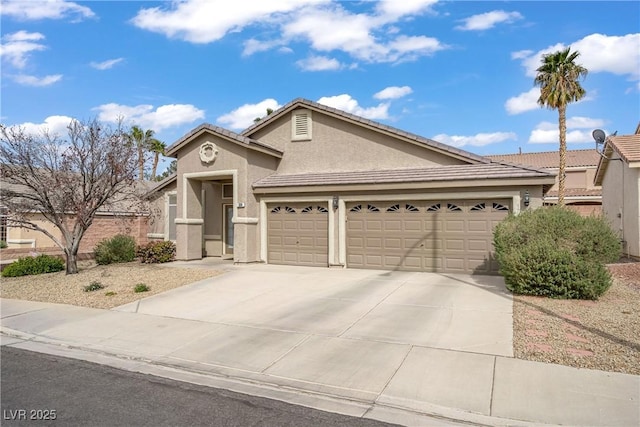 view of front of property with a tile roof, driveway, stucco siding, and an attached garage