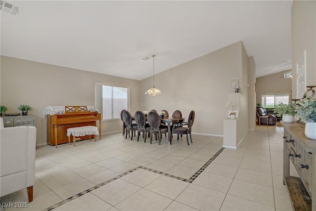 dining room featuring visible vents, baseboards, lofted ceiling, an inviting chandelier, and light tile patterned floors