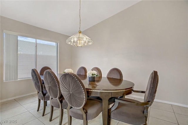 dining room featuring light tile patterned floors, baseboards, vaulted ceiling, and a notable chandelier